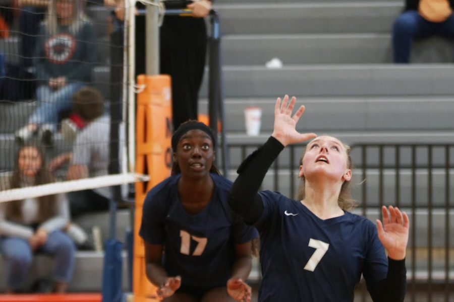 Looking up, sophomore Sydney Fiatte prepares to set the ball for her teammate while senior Faith Archibong watches from behind her. 