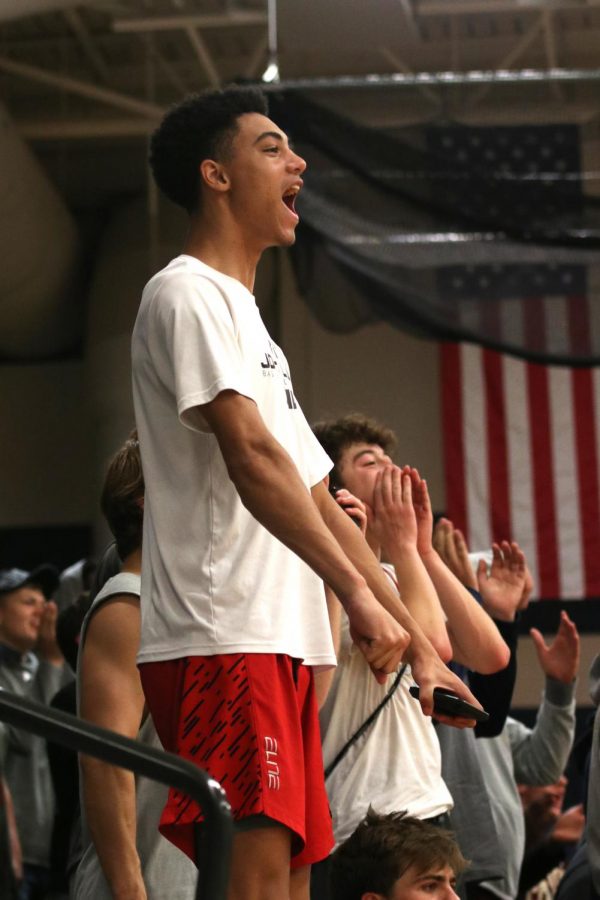 In the student section, sophomore Adrian Dimond cheers after a point is scored. 