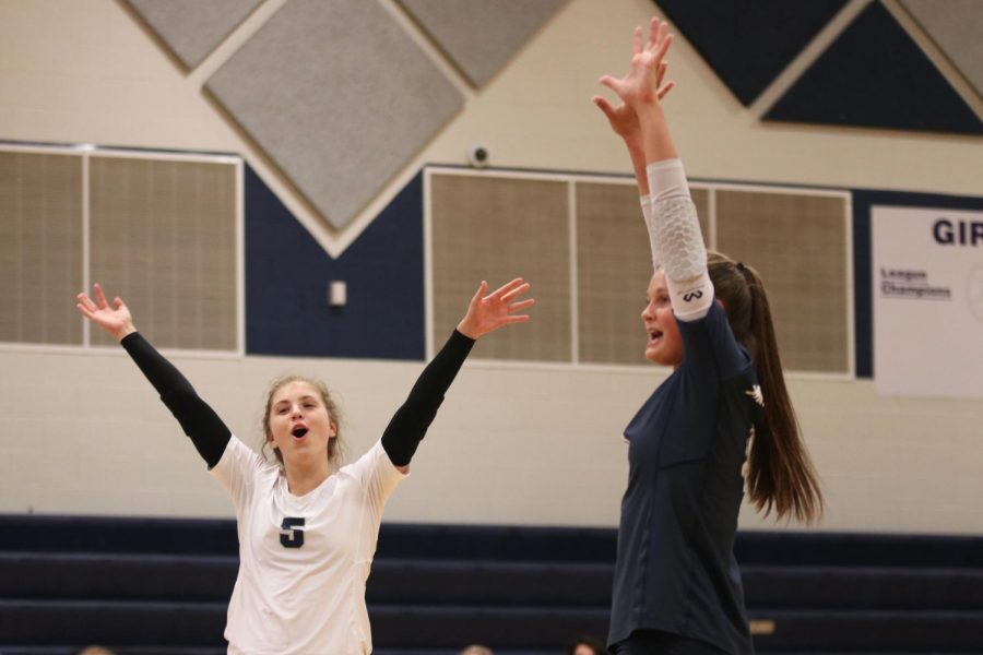 Smiling after scoring a point, junior Anna Judd celebrates with a teammate. 