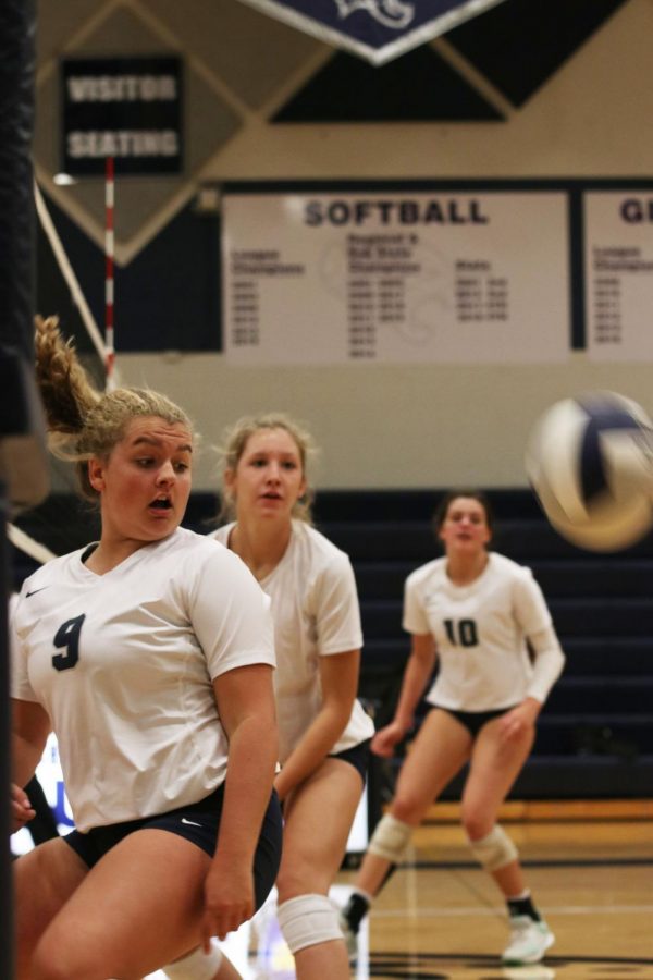 Watching the ball soar over the net, junior Landry Haydock turns her head to look behind her.