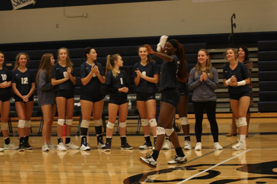 Arm wound back, senior Faith Archibong prepares to throw a Mill Valley Volleyball shirt into the audience.