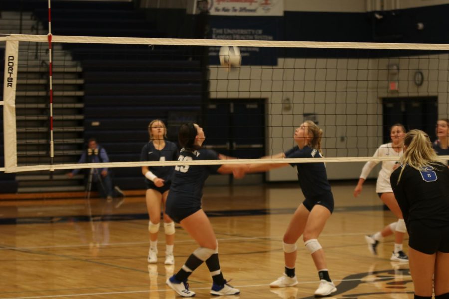 Turning toward each other, junior Carlie Bradshaw and sophomore Kate Roth work together to hit the ball.
