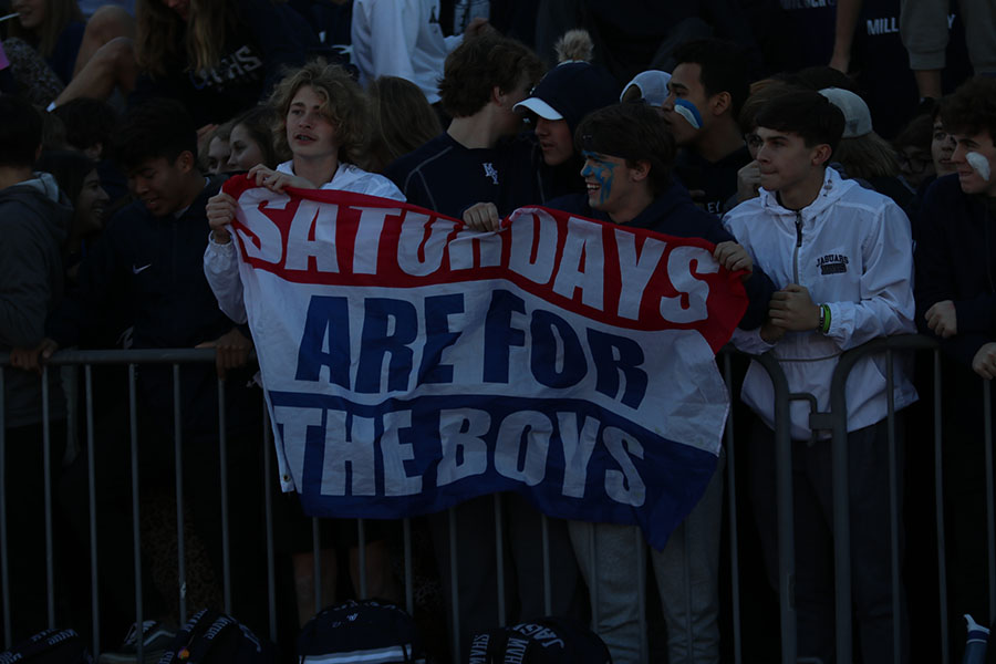 Holding a sign, the crowd shows support for the team. 
