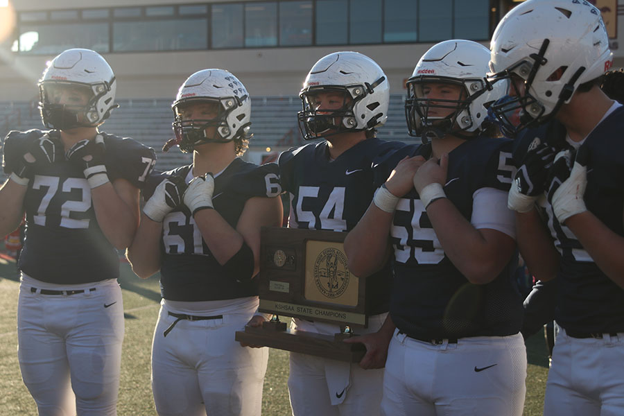 Holding the state trophy, senior Mason Scott poses for a picture. 
