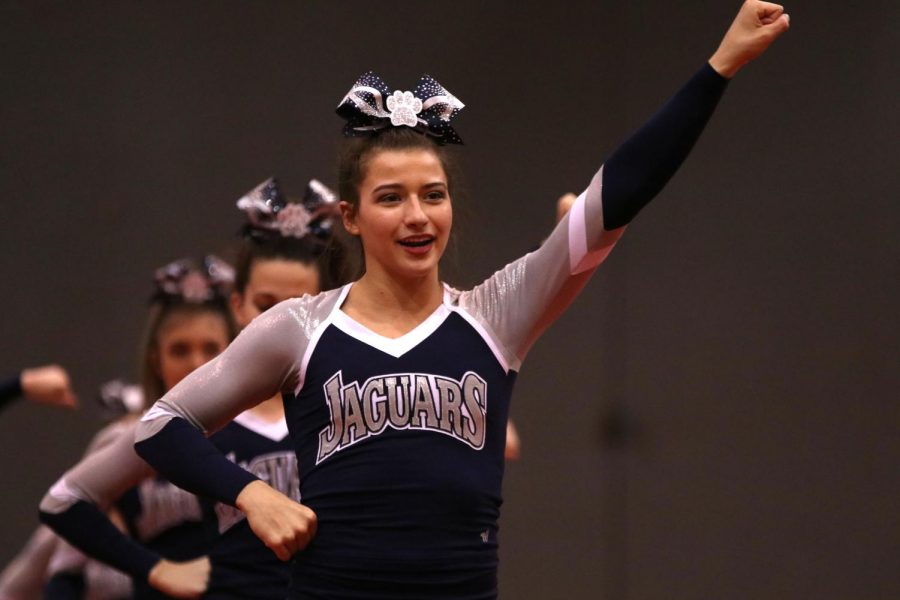 Finishing the crowd leading portion, senior Ellie Kerstetter holds her position. The cheer team received a two rating at their first competition of the season Saturday, Nov. 16.