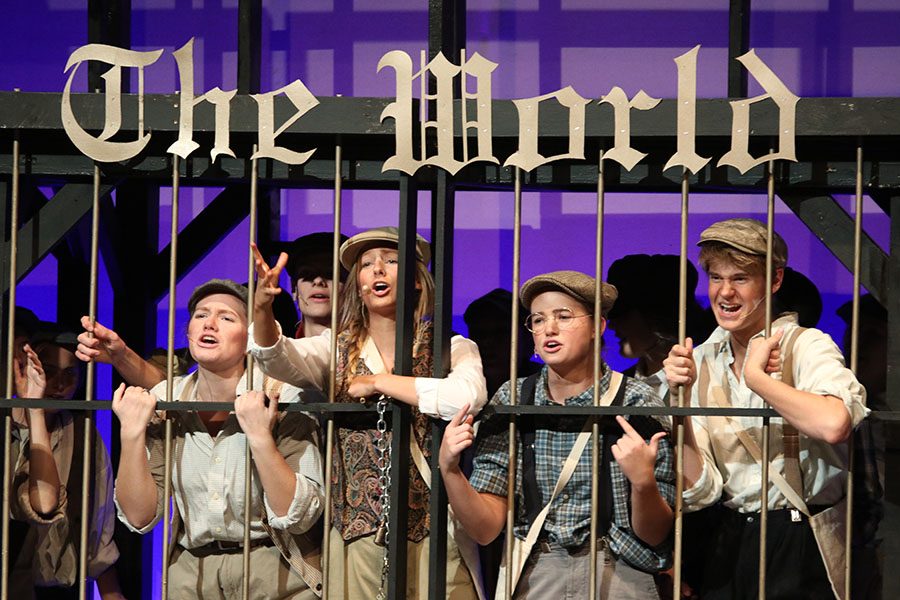 Reaching out, senior Annie Bogart and the rest of the Newsies want to be let out.