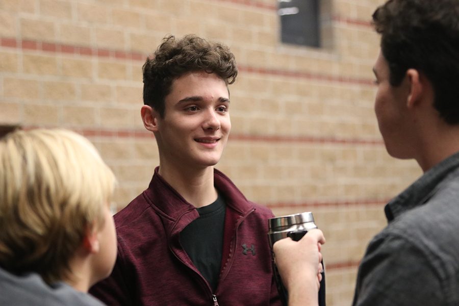 Smiling at his friends, freshman Brayden Heath chats with his castmates before their musical rehearsal for “Newsies”.