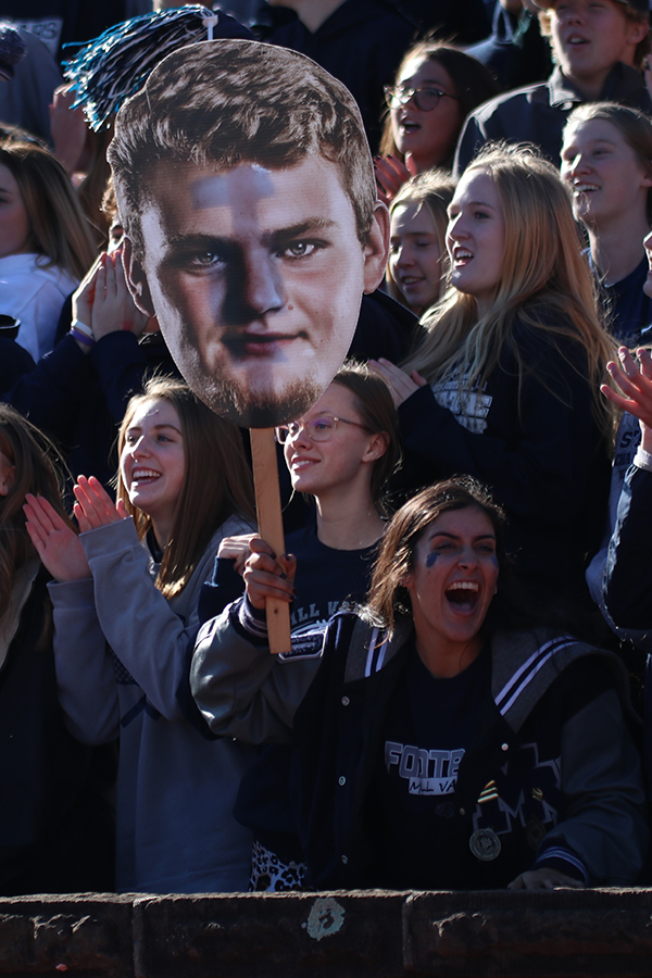 Holding a fat head of offensive linemen Kyle Kelly, senior Jessica Garcia cheers him on.