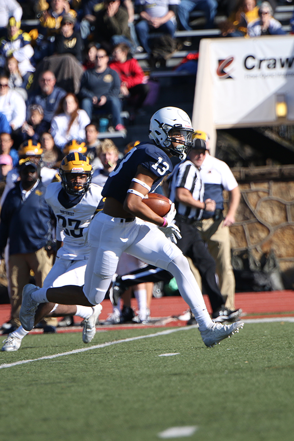 Avoiding Wichita NW defenders, senior Zach Mills runs downfield.