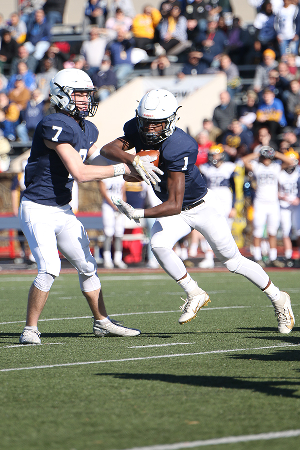 To confuse Wichita NW defenders, junior Cooper Marsh hands off the ball to junior Quin Wittenauer.