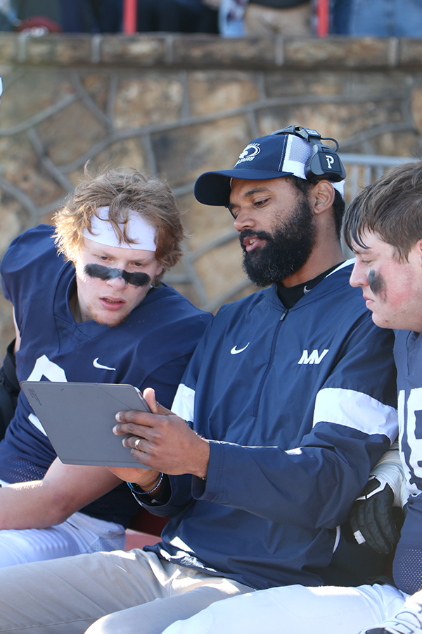 Going through previous plays, defensive line coach Cox talks with senior Kendal Christopher.