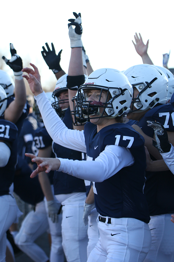 Getting ready for the end of the game, sophomore Aiden Jacobs cheers excitedly with his teammates.