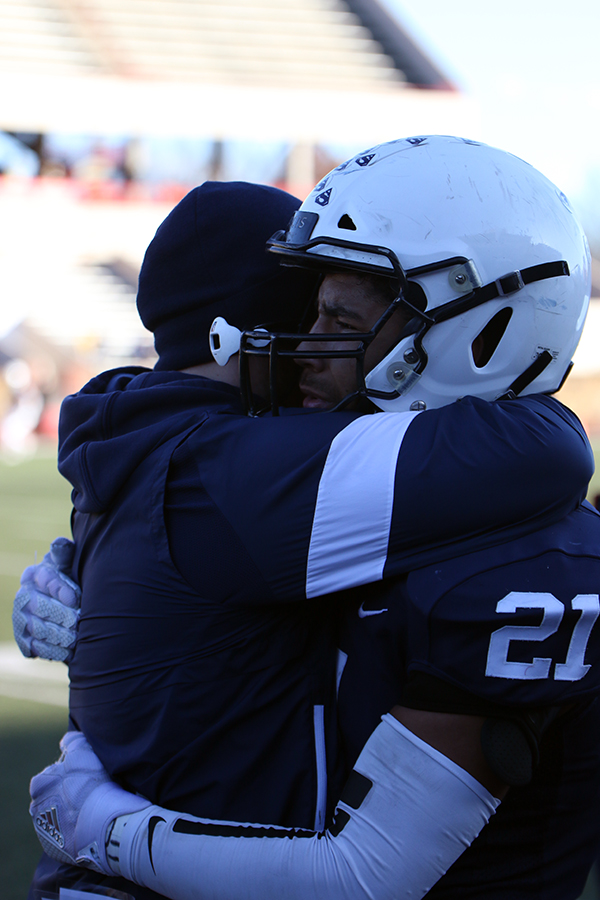 Getting emotional as the game is about to end, senior Tyler Green engulfs running back coach Josh Barnes.