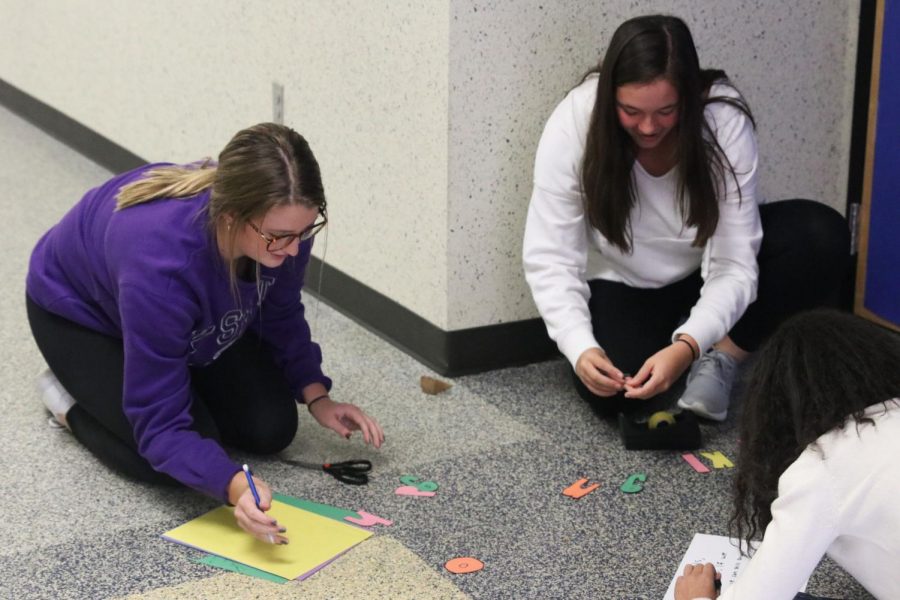 Cutting out letters, juniors Kenzie Harris and Ryleigh Reigle create their seminar door decorations. Throughout the past couple weeks, students participated in the annual Red Ribbon Week with this fun activity to express the effects of vaping and alcohol on teens.