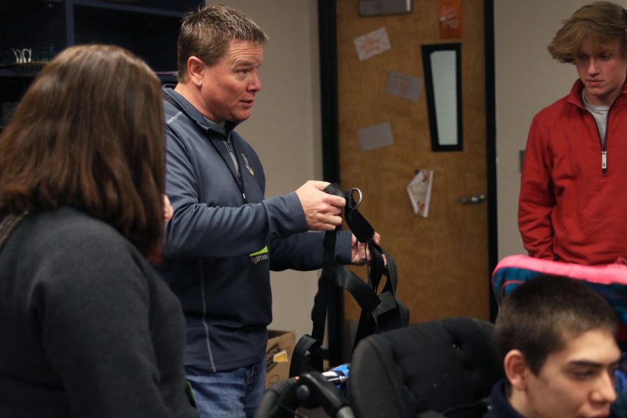 Holding up the straps, Dave Hayden talks to the engineering students about their project.