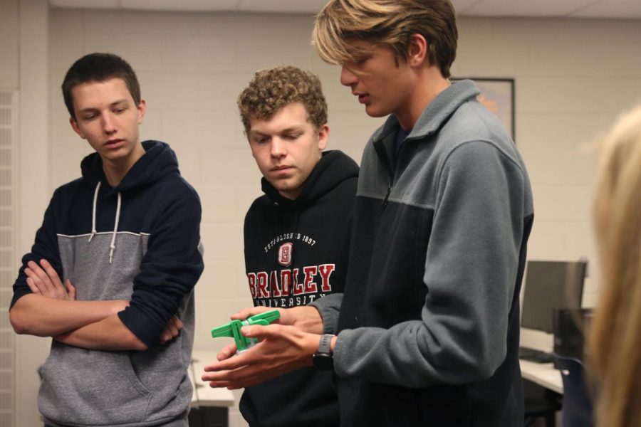 Holding a piece from the project, senior Nathan Greenfield explains how it works.