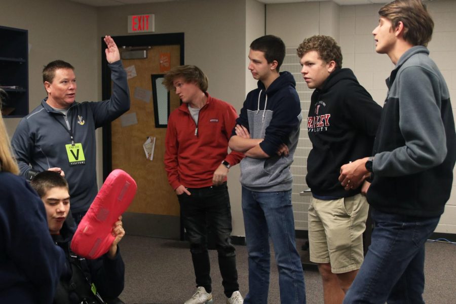 Gesturing with his arm, Dave Hayden discusses the project with the engineering students.
