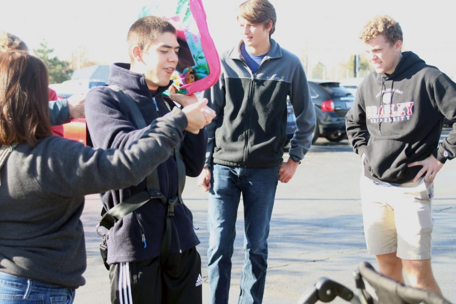 Standing up, Olathe West senior Ty Hayden wears the harness constructed by the engineering students.