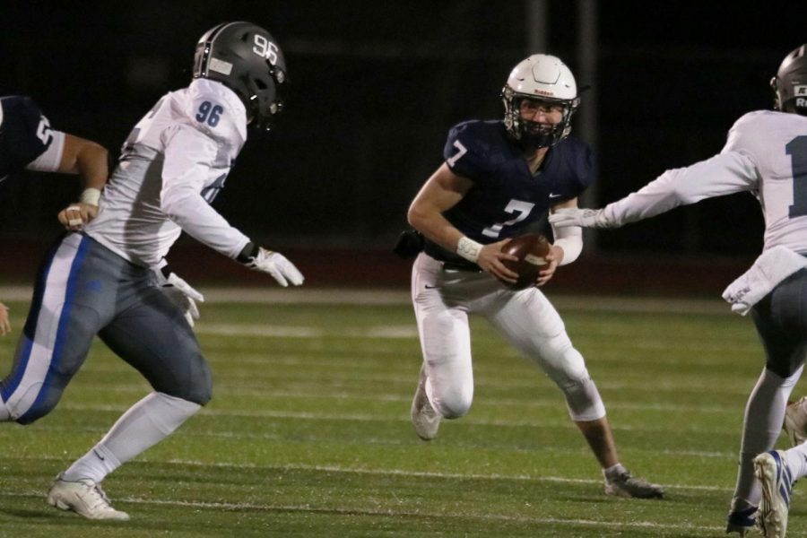 Carrying the ball, junior Cooper Marsh attempts to run through the defensive line.