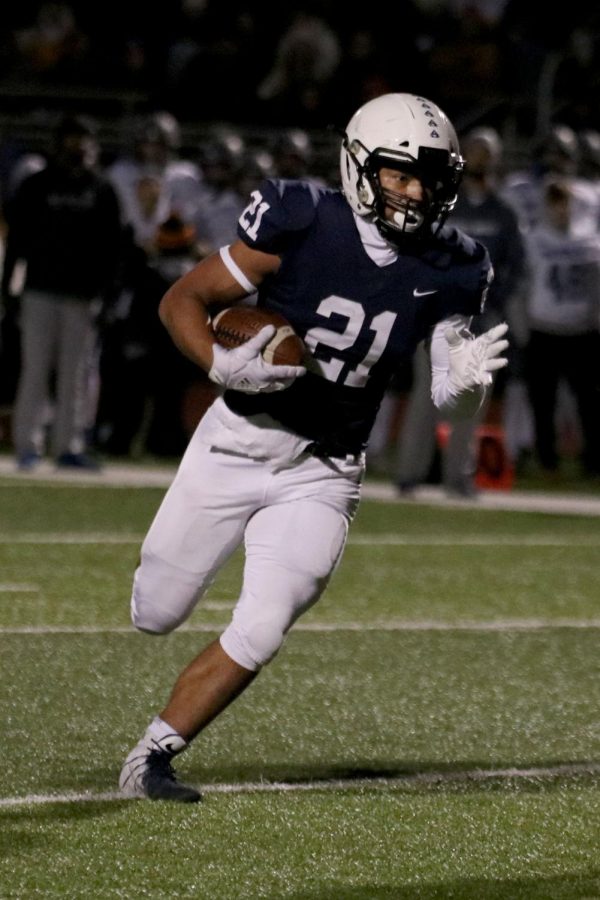 With possession of the ball, senior Tyler Green runs downfield.