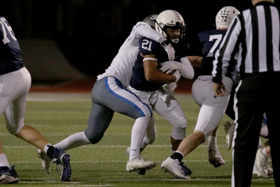 Carrying the ball, senior Tyler Green tries to remove himself from a defender’s grip.