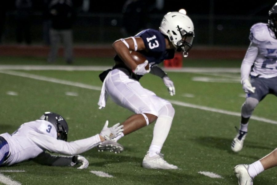 With possession of the ball, senior Zach Mills attempts to run past the opposing team.