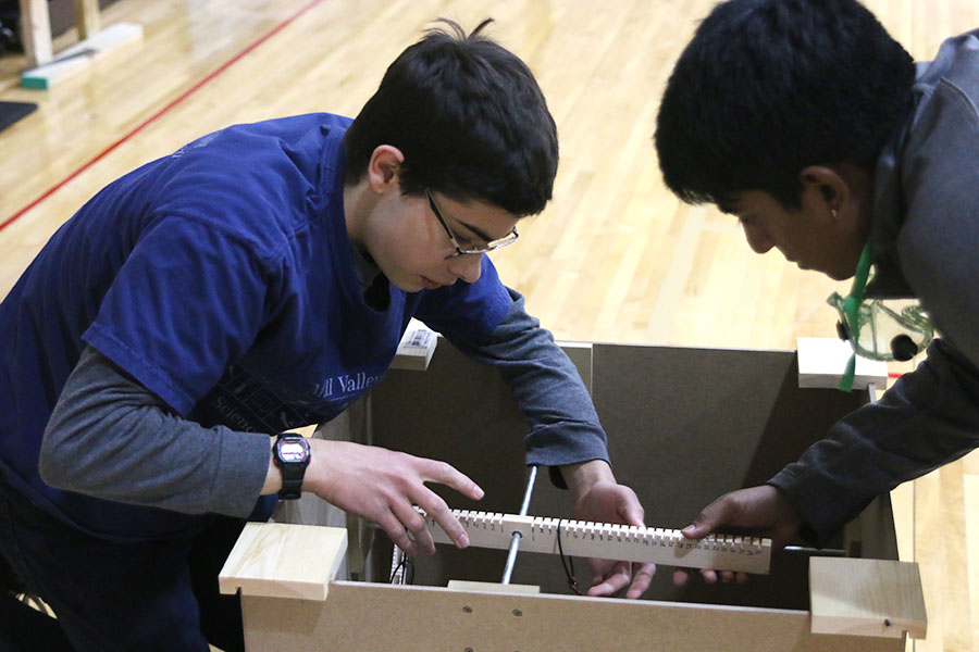 In addition to a written test, junior Alex Whipple and senior Srikar Turaga adjust their device for "Machines" to determine the ratios between three unknown masses at the O-Town Throwdown tournament hosted by Olathe North Saturday, Nov. 16. "Machines" is an event where a team of up to two people construct a device that can determine the mass ratios of different masses. The two placed seventh out of 25 teams.