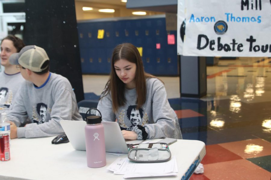 Waiting for students to check in to the tournament, sophomore Grace Emerson works on her computer. The debate team hosted the Aaron Thomas Memorial Invitational tournament Friday, Nov. 15 and Saturday, Nov. 16.