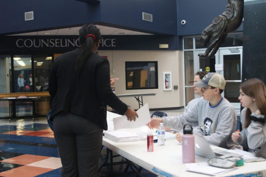 Explaining where a room is, sophomore Noah Reed helps a fellow debate student with directions.
