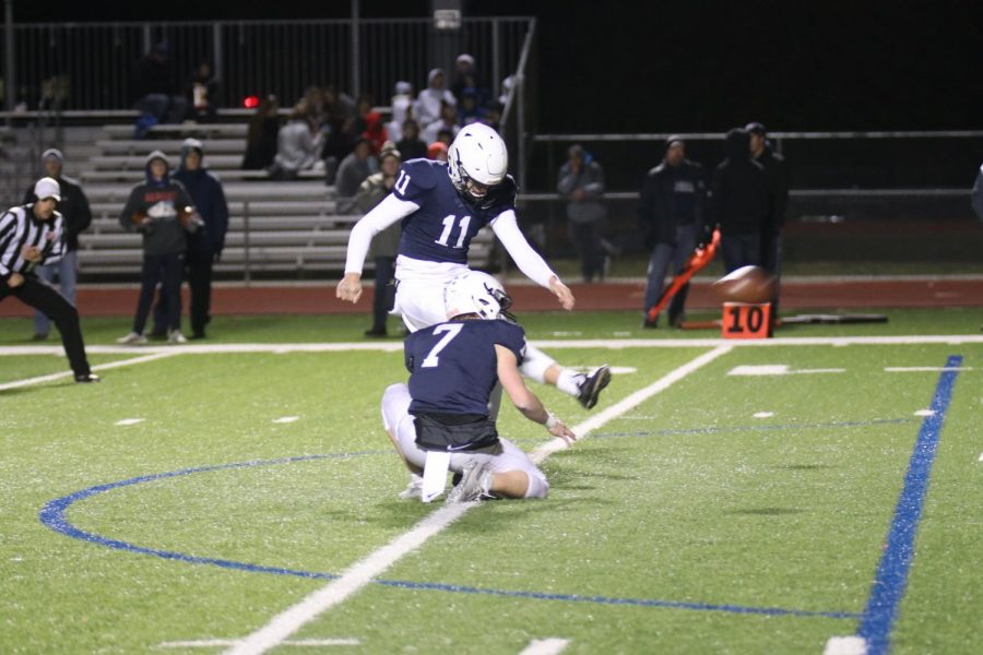 Swinging his leg, junior Chris Tennant kicks a field goal.