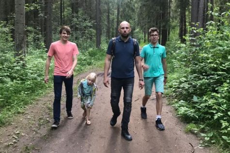 Senior Issac Mcelwee (left) walking down a trail with his Russian host family. 
