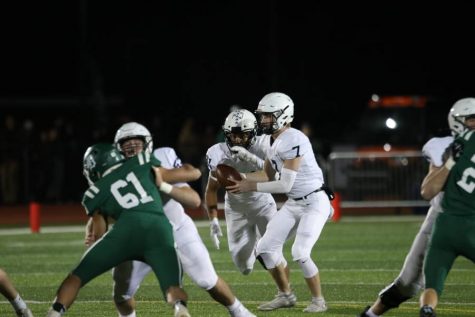 Handing off the ball to running back senior Tyler Green, quarterback junior Cooper Marsh attempts to make a play on Friday, Nov. 15. The team played well offensively and defensively making the final score 18-7. 