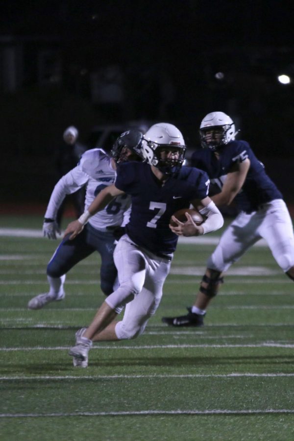 With the ball in one hand, junior Cooper Marsh runs.