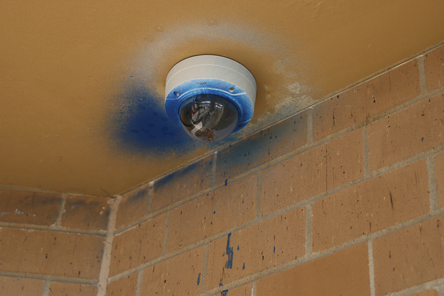 A security camera outside the media center remains covered in blue spray paint from the vandalism.