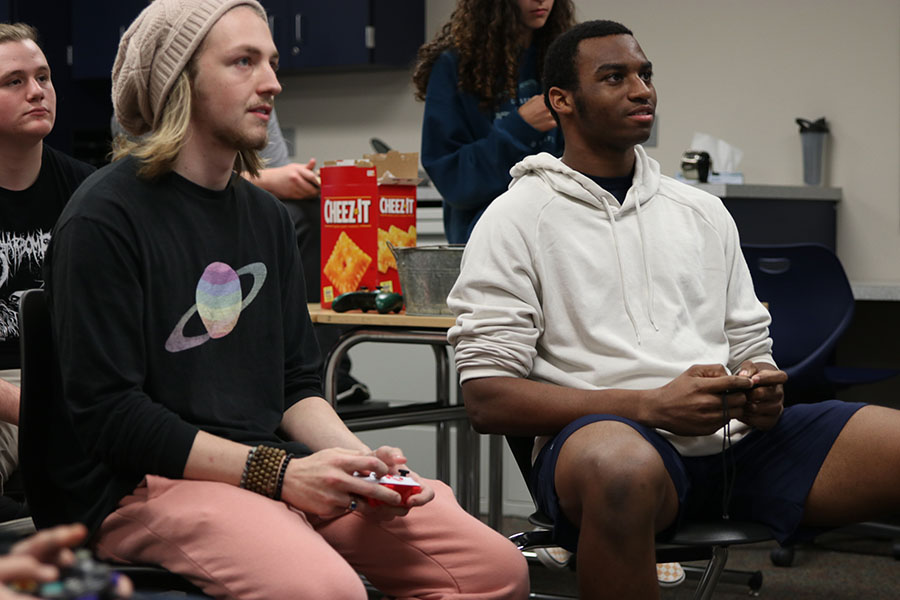 Focusing on the screen, seniors Sam Crain and Tabari Johnston battle against each other along with two other people.