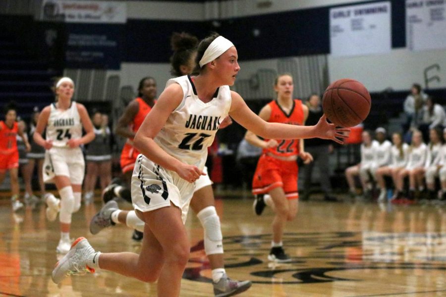 Reaching out her arm, junior Katherine Weigel dribbles the ball.