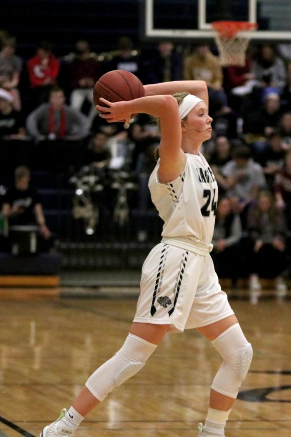 Holding the ball above her head, sophomore Emree Zars passes the ball to a teammate.