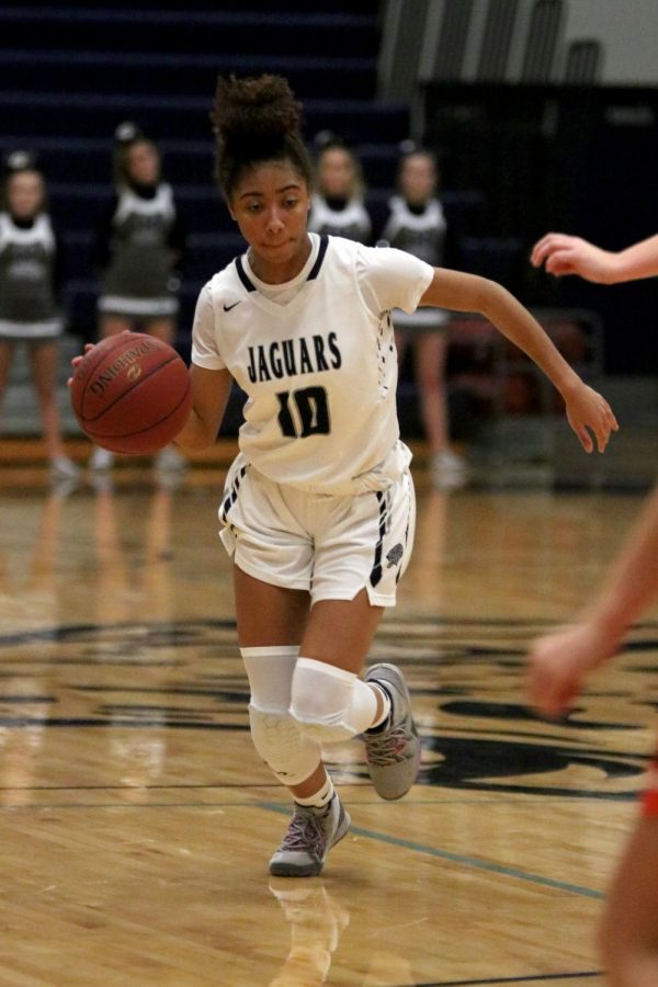 Running with the ball, junior Vania Barnett heads down the court.