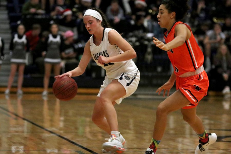 Dodging an opponent, junior Katherine Weigel dribbles the ball.