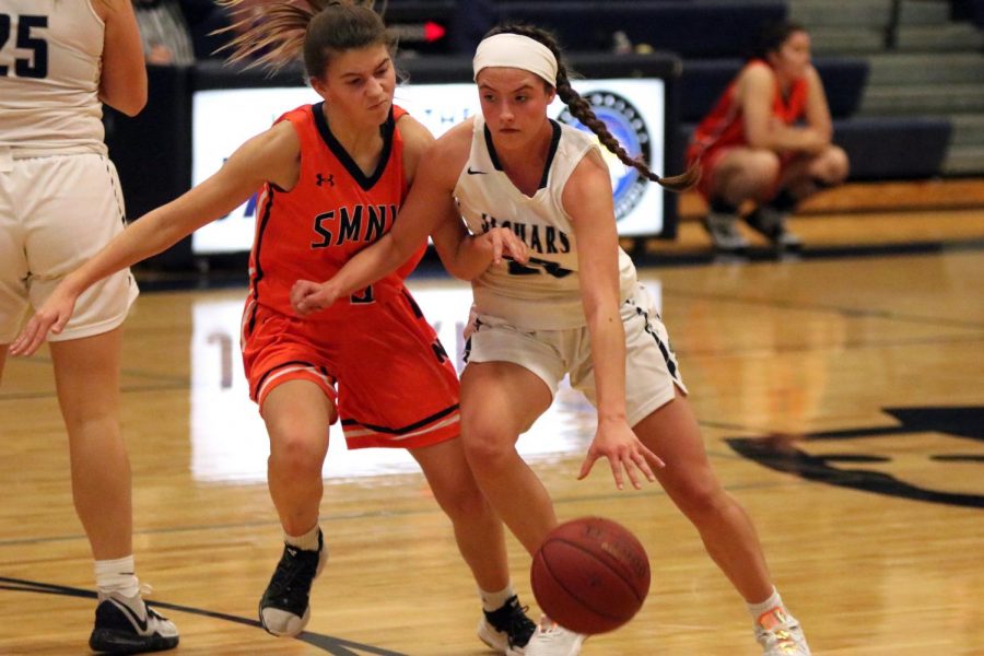 Dribbling the ball, junior Katherine Weigel tries to make it past a defender.