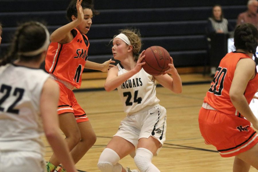 Preparing to pass the ball to a teammate, sophomore Emree Zars maneuvers around her opponents.