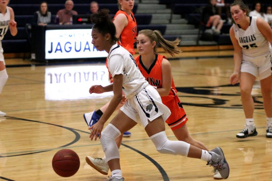 Running down the court, junior Vania Barnett dribbles the ball.