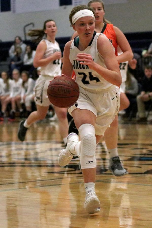 Dribbling the ball, sophomore Emree Zars heads down the court.