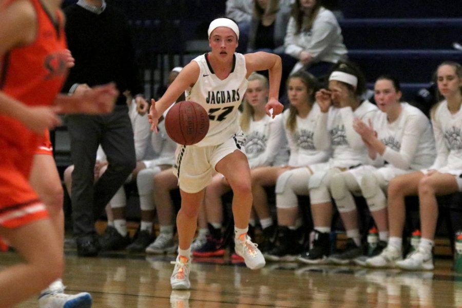 Looking ahead, junior Katherine Weigel dribbles the ball down the court.