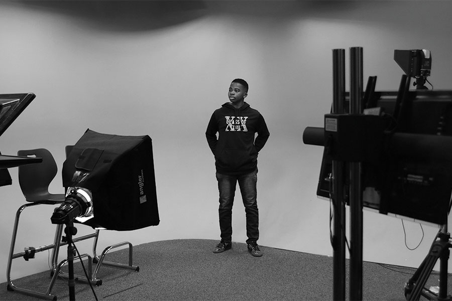 As he stands on a replicated set of a photoshoot, senior Tripp Starr poses with his hands in his pockets and glances to his side. 