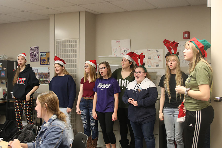 Choir members sing a Christmas carol while StuCo members collect money.