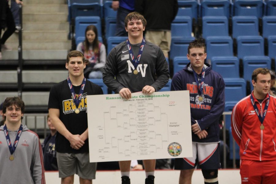 Junior Ethan Kremer poses with the winning bracket after winning the 220-pound weight class on Saturday, Feb. 23. Photo by Marah Shulda. 