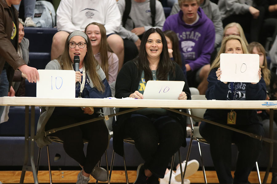 Showing off the scores, journalism teacher Dorothy Swafford, communication teacher Nicole Porter, and engineering teacher Gayle Kebodeaux give seniors Rylee McElroy and Josh Glunt three 10s.
