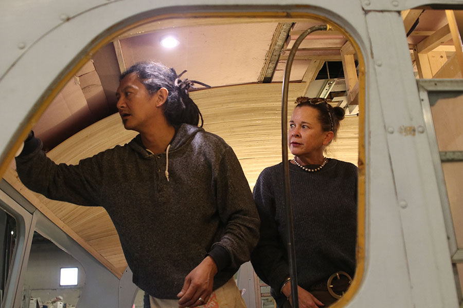 Tom and Kristen Huang work on the bamboo ceiling paneling of the bus. 