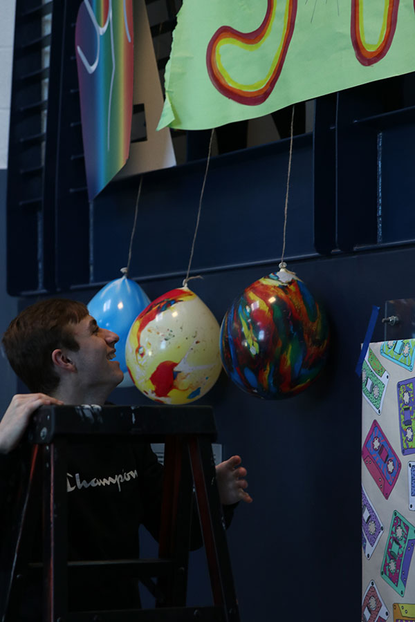 StuCo vice president Wyatt Lindsey helps move the balloons near the senior poster. 